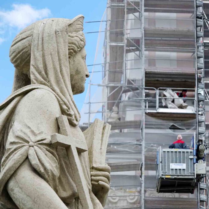 Voller Sorge beobachtet sie die Bauarbeiten am Turm der Stiftskirche.