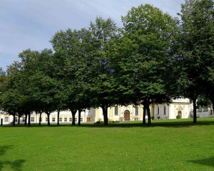 Im Schatten der Lindenbäume durchquert man den Klosterhof von Stift Stams.