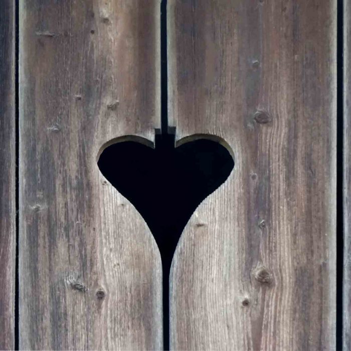 Das ausgeschnittene Herz in der Holztür signalisert geläufig den Zugang zum Plumpsklo.