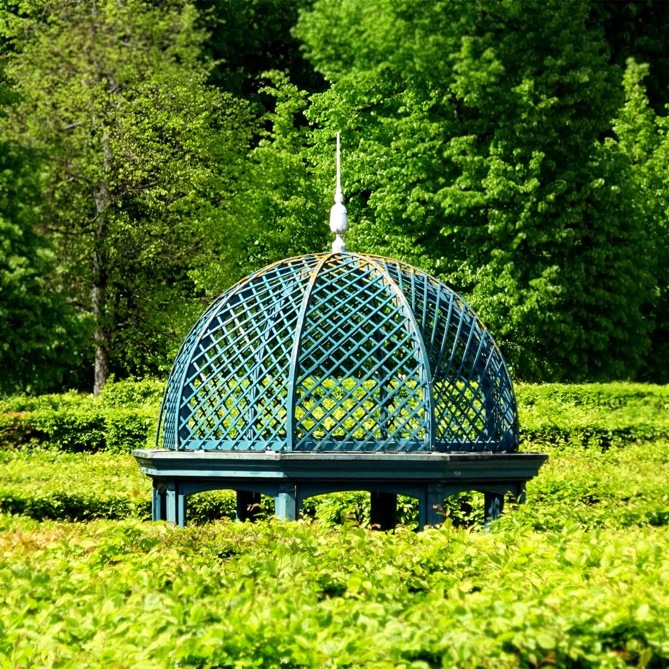 Eine typische Pavillonhaube thront über den Buchenhecken.