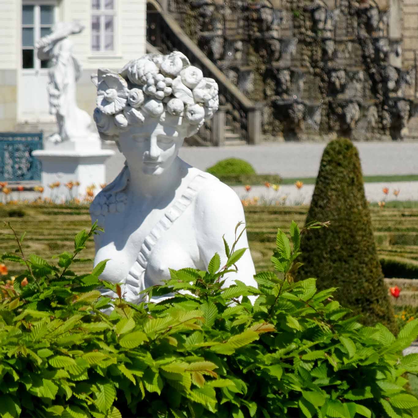 Die Göttin Flora schaut interessiert dem Treiben in den Gärten zu.