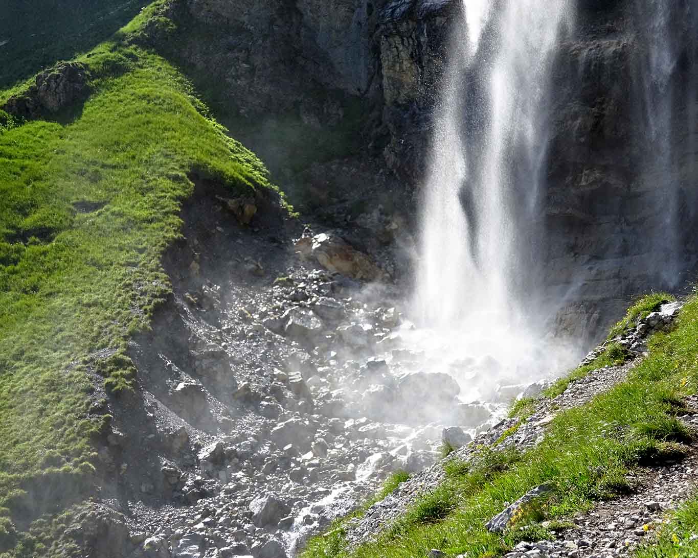 Der Nebel des aufprallenden Wassers netzt erfrischend mit winzig kleinen Wassertröpfchen die Wiesen und Steine.