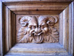 Ein Geisen-oder Bacchuskopf ist in die hölzerne Tür der Basilika zu Assisi geschnitzt.