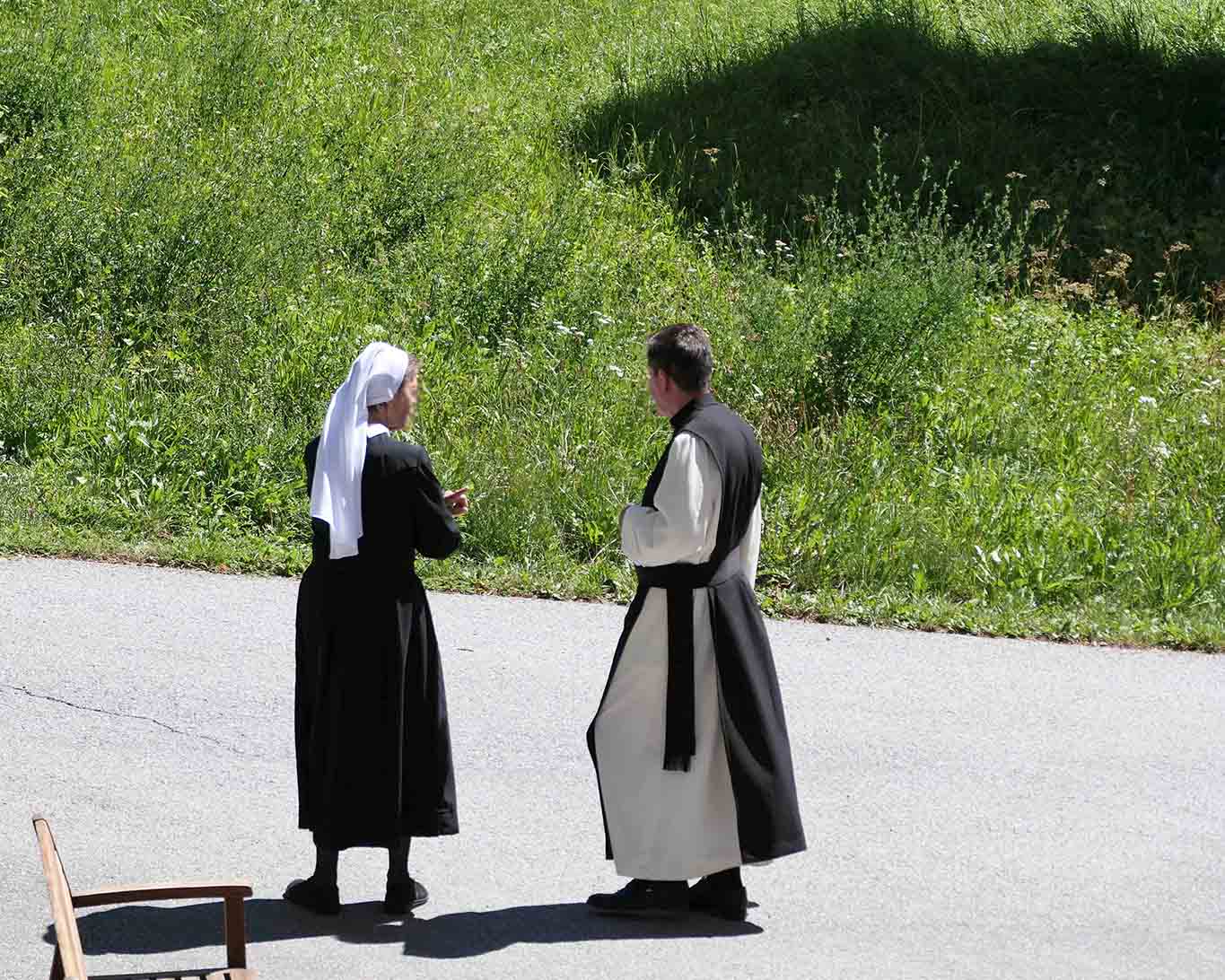 Nonne der Barherzigen Schwestern mit Zisterzienser-Mönch im Gespräch.