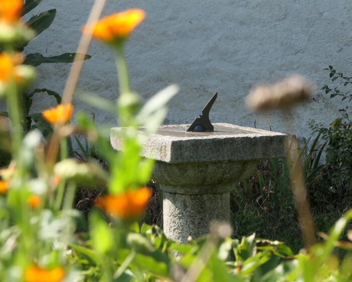 Sonnenuhr mit Ringelblumen im Heilkräutergarten des Stifts Seitenstetten.