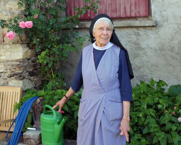 Schwester Hedwig vom Kloster Wernberg mit ihrer grünen Giesskanne steht Modell.