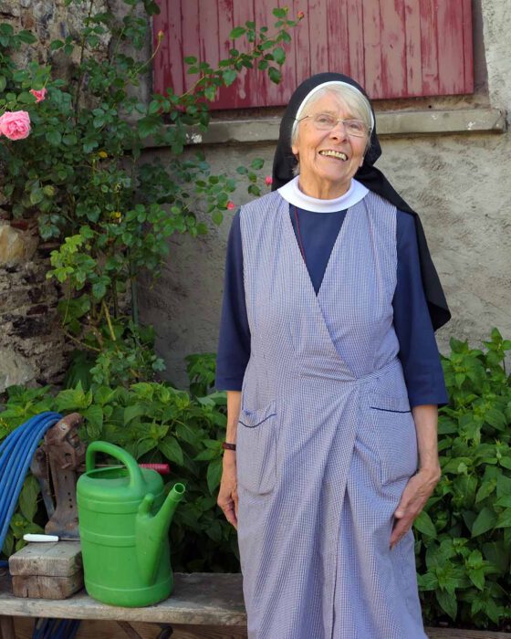 Schwester Hedwig vom Kloster Wernberg fröhlich mit Giesskanne.