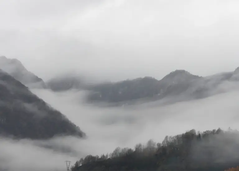 Nebelschwaden nach intensivem Herbstregen in den Alpen bei Bergamo.