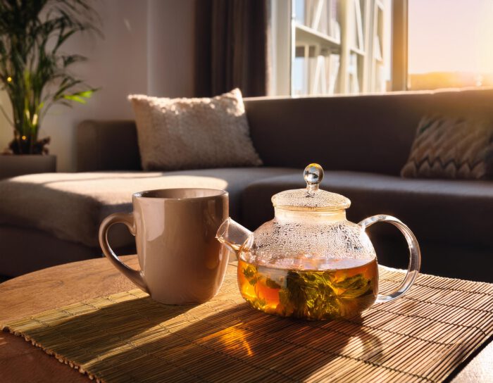 Kräutertee im Wohnzimmer am Abend. Tasse und Kanne