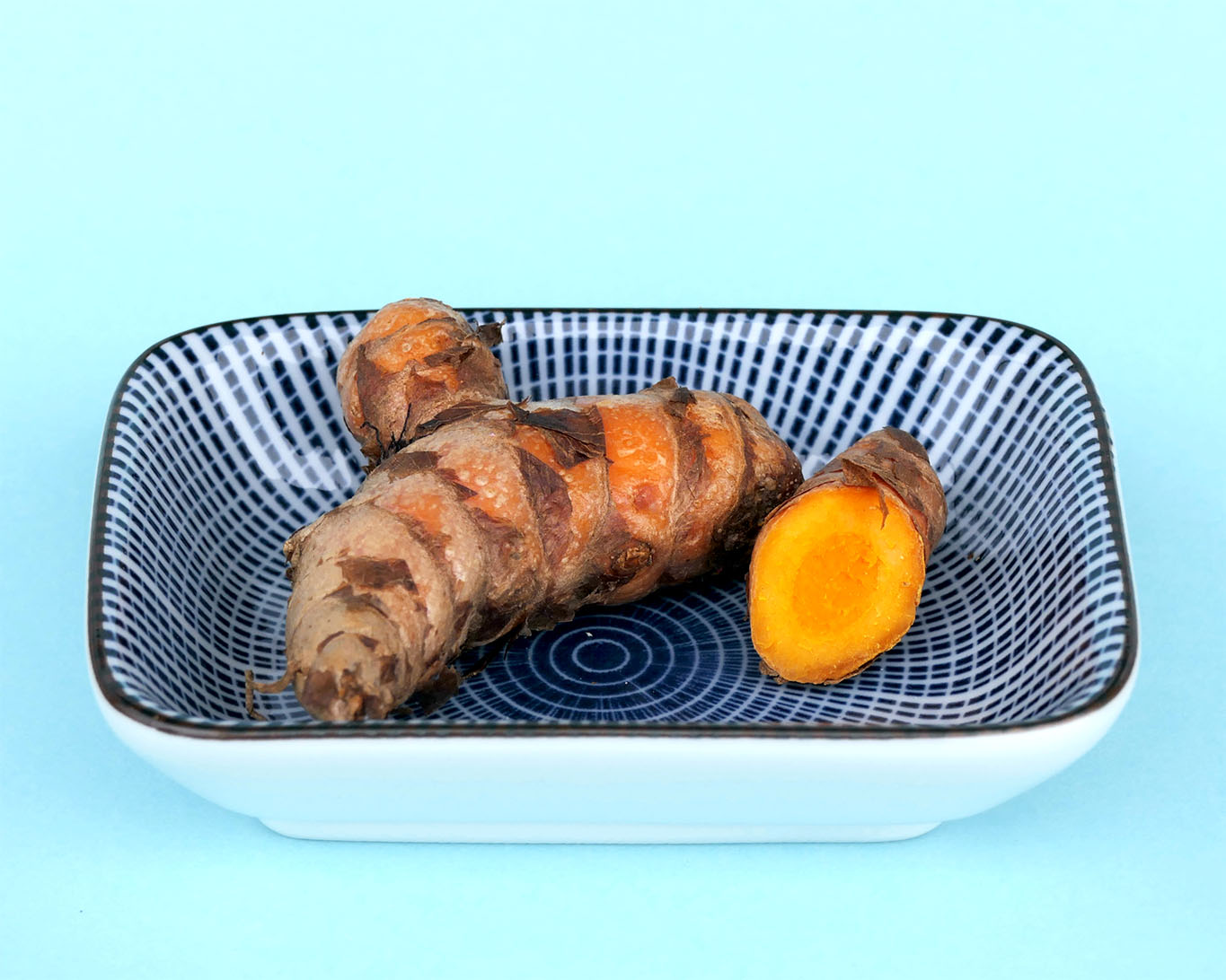 Die typische intensive rötlich orange Farbe des Wurzelquerschnitts enttarnt den Kurkuma.